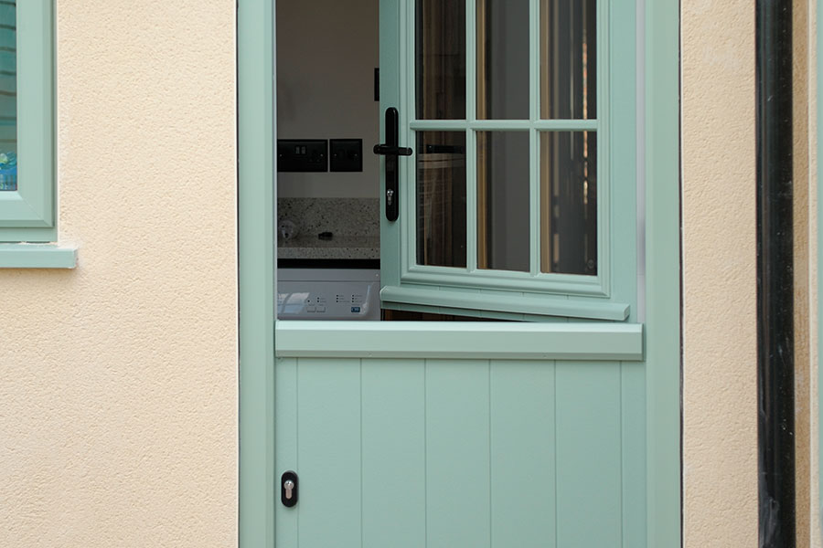 Green traditional style stable door with astragal bars